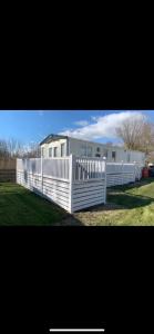 a white fence in front of a trailer at Meadows 3 NEW BEACH HOLIDAY PARK in Dymchurch