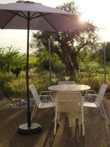 einen Tisch und Stühle mit Sonnenschirm auf einer Terrasse in der Unterkunft Casa la Era in Salas Bajas