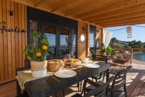 a dining table on a patio with a view of the water at Mara's Coast - Giulia in Drage
