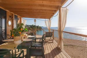 a porch with a table and chairs and the ocean at Mara's Coast - Giulia in Drage