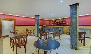 Un restaurante con mesas y sillas y paredes rojas. en Treebo Prince, en Kottayam