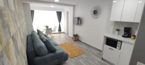 a living room with a blue couch and a kitchen at Olimp Family - Olimp Sea View Apartments in Olimp