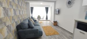 a living room with a couch and a television at Olimp Family - Olimp Sea View Apartments in Olimp