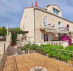 ein Haus mit einem Balkon und einem Gebäude in der Unterkunft Apartments Milka & Miho in Dubrovnik