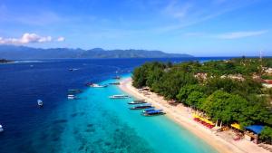 an aerial view of a beach with boats in the water at Gili Mesari Cottages & Homestay in Gili Trawangan