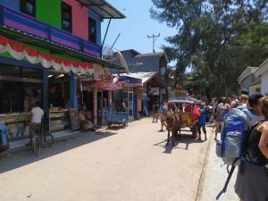 a street with a horse drawn carriage in a town at Gili Mesari Cottages & Homestay in Gili Trawangan