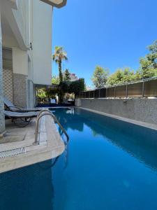 a swimming pool with blue water next to a building at Sempati Apart Hotel in Alanya