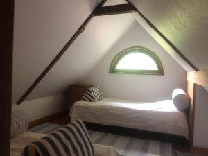 a attic room with a bed and a window at Cottage on unique farm in Höör