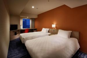 a hotel room with two beds and a television at Sunshine City Prince Hotel Ikebukuro in Tokyo