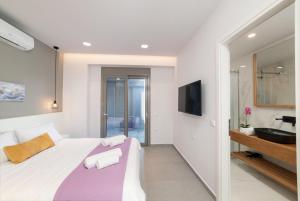 a bedroom with a large bed and a bathroom at Villa Ampela by PosarelliVillas in Agia Marina Nea Kydonias