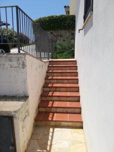 una rampa di scale che porta a un edificio di Casa Solaria Villetta singola panoramicissima a Costa Rei