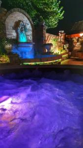 una gran piscina de agua con una fuente por la noche en Motel Castello, en Smederevska Palanka