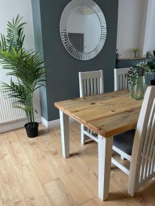 a wooden table in a dining room with a mirror at Bentley Place in Crewe