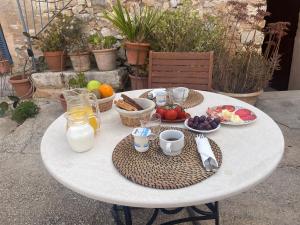 una mesa blanca con desayuno y bebidas. en Agroturismo Finca Dalt Murada en Binissalem