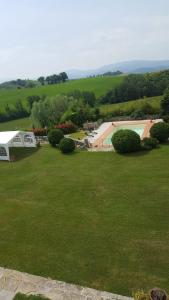 un ampio cortile verde con piscina e alberi di Villa Medicea Lo Sprocco a Scarperia
