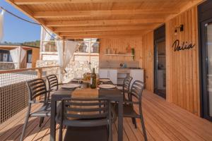 eine Holzterrasse mit einem Tisch und Stühlen darauf in der Unterkunft Mara's Coast - Dalia in Drage