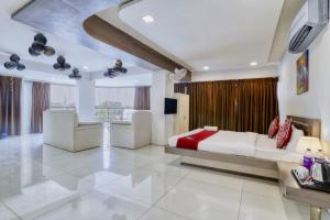 a large bedroom with a large bed and a tv at Hotel Dwarika Inn in Indore