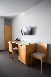 a room with a desk, chair and a television at Hotel Atom Třebíč in Třebíč