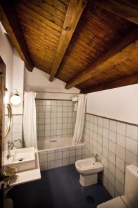 a bathroom with a tub and a toilet and a sink at Posada Real del Buen Camino in Villanueva de Campeán
