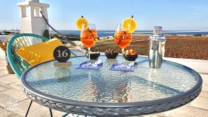a glass table with four wine glasses on it at Paradise Sea Terrace in Monopoli
