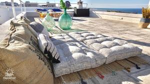 a couch sitting on a patio near the ocean at Paradise Sea Terrace in Monopoli
