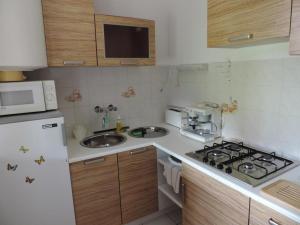 a kitchen with a stove and a sink and a microwave at Füvesi Vendégház in Balatonfüred +11 photos