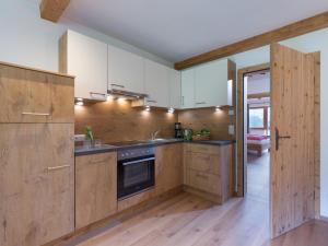 kuchnia z drewnianymi szafkami i kuchenką w obiekcie BERGappartement KINK w mieście Hopfgarten im Brixental