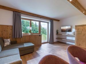 ein Wohnzimmer mit einem Sofa und einem TV in der Unterkunft BERGappartement KINK in Hopfgarten im Brixental