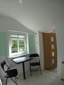 um quarto com uma mesa e cadeiras e uma janela em na Slowackiego em Szklarska Poręba