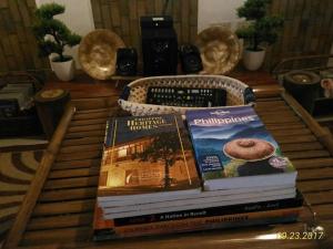 uma pilha de livros em cima de uma mesa em A Filipino Rustic Style Duplex in Rosario, Cavite UNIT A em Rosario