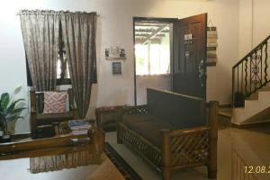 uma sala de estar com um sofá e uma mesa em A Filipino Rustic Style Duplex in Rosario, Cavite UNIT A em Rosario