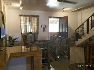 uma sala de estar com um sofá e uma mesa em A Filipino Rustic Style Duplex in Rosario, Cavite UNIT A em Rosario