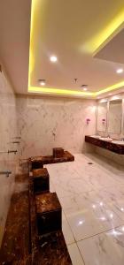 a large bathroom with a marble floor and sinks at Al Ebaa Hotel in Makkah