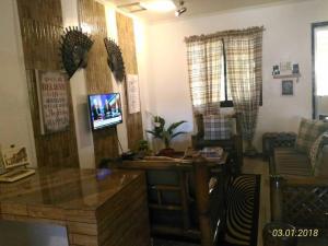 uma sala de estar com uma secretária e uma televisão em A Filipino Rustic Style Duplex in Rosario, Cavite UNIT A em Rosario