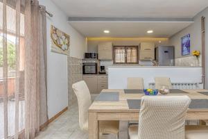 a kitchen and dining room with a wooden table and chairs at Emanuela with Private Pool in Loborika