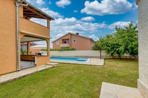 a backyard with a swimming pool and a house at Emanuela with Private Pool in Loborika