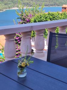 un jarrón de flores sentado en una mesa en un balcón en Villa Luma Apartments en Labin