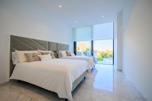 2 camas en una habitación con ventanas grandes en Villa Martin Stone- Las Colinas Golf Country, en Orihuela Costa 20 fotos más