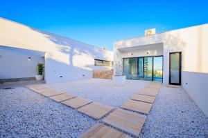 Casa con paredes blancas y patio. en Villa Martin Stone- Las Colinas Golf Country, en Orihuela Costa