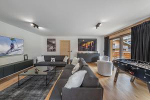 a living room with a couch and ping pong tables at Quintessence - Apt B303 - BO Immobilier in Châtel