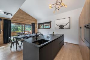 a kitchen with a sink and a table with chairs at Quintessence - Apt B303 - BO Immobilier in Châtel