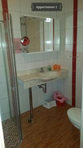 ein Badezimmer mit einem Waschbecken, einem Spiegel und einem WC in der Unterkunft Haus Mareén in Graal-Müritz