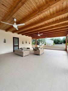 un gran patio con sofás y techo de madera. en Villa Sikè, en Módica