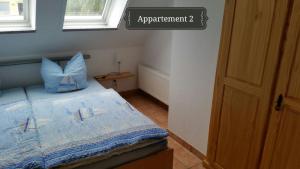 ein Schlafzimmer mit einem Bett mit blauen Kissen darauf in der Unterkunft Haus Mareén in Graal-Müritz