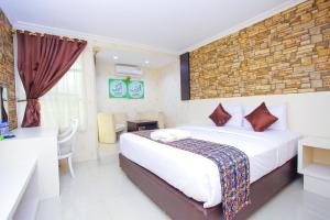 una habitación de hotel con una cama grande y un comedor en The Djakarta Anandita Syariah Hotel, en Samarinda