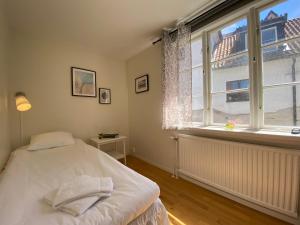 a bedroom with a bed and a large window at Hamngatan Logi in Visby