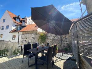 a patio with a table and chairs and an umbrella at Hamngatan Logi in Visby