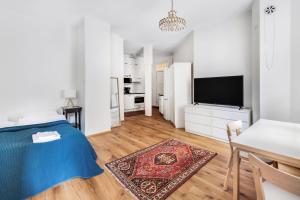 a white apartment with a blue bed and a kitchen at WeHost Oikokatu in Helsinki