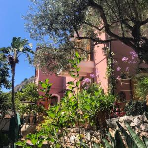 un edificio rosa con plantas delante en Villa Britannia, en Taormina