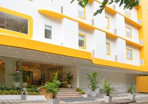 a building with a yellow and white facade at Bloom Hotel - Brookefield in Bangalore